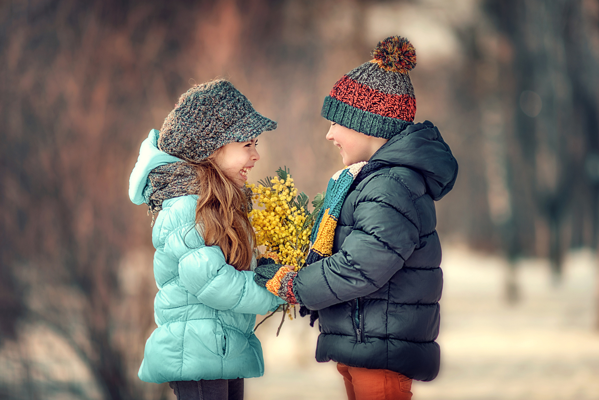 Зимой дети любят. Мальчик дарит девочке цветы. Детишки зимой красивые.